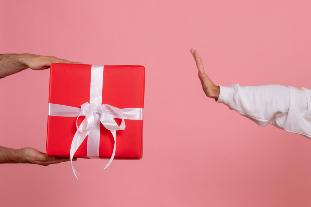 front-view-young-woman-holding-little-present-accepting-gift-from-man-pink-wall.jpg